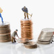 Figurines of manual workers with stacks of coins